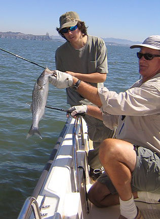 Alex lands a young striper